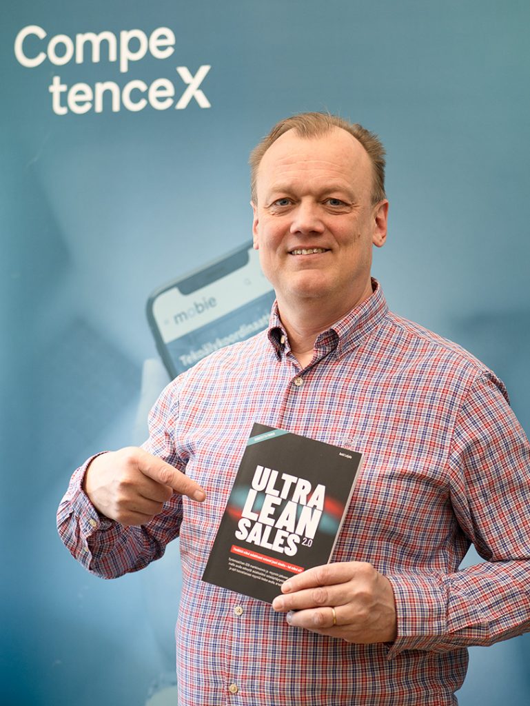 Antti Leijala seisomassa ja esittelemässä kirjaa kameralle.